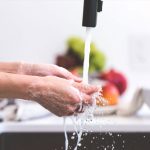 Photo of a woman washing her hands in a sink